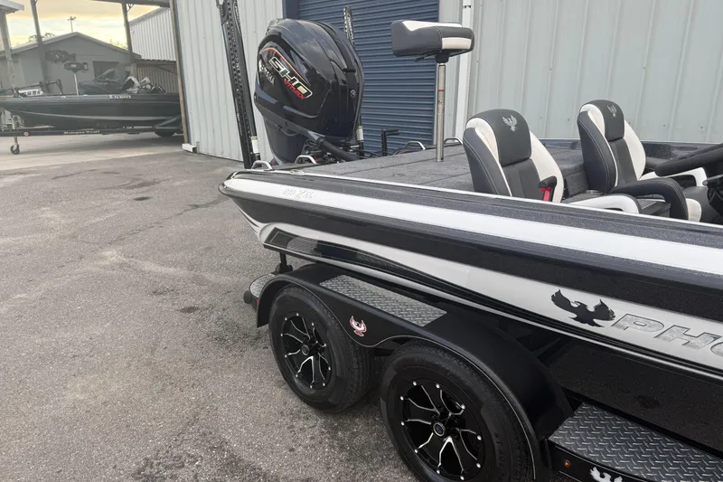Slide: The Image of 2025 Phoenix 919 ZXL boat with Yamaha engine, parked on a trailer near a warehouse. - 4