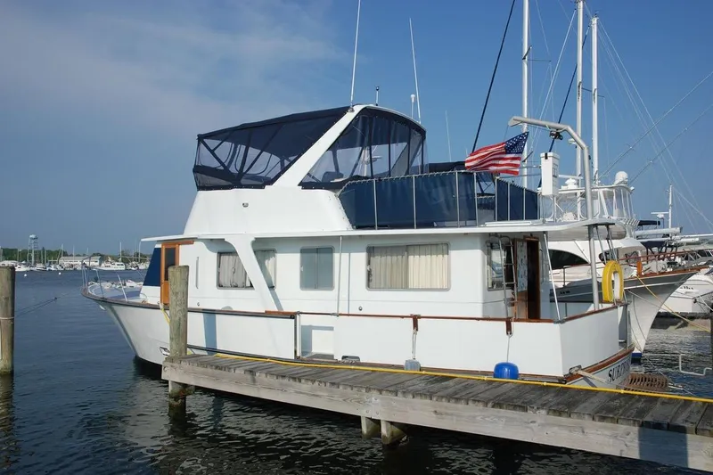 The Image of 1985 Pearson 43 Trawler docked at marina with American flag. - 0