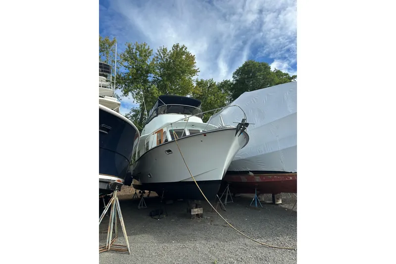 Slide: The Image of 1985 Pearson 43 Trawler on dry dock, surrounded by trees and other boats. - 2