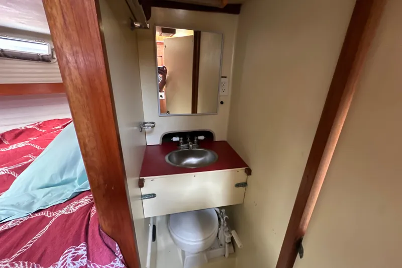 Slide: The Image of 1985 Pearson 43 Trawler bathroom with sink, mirror, and toilet. - 31