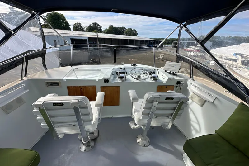 Slide: The Image of 1985 Pearson 43 Trawler helm with dual seats, steering wheel, and navigation equipment. - 45