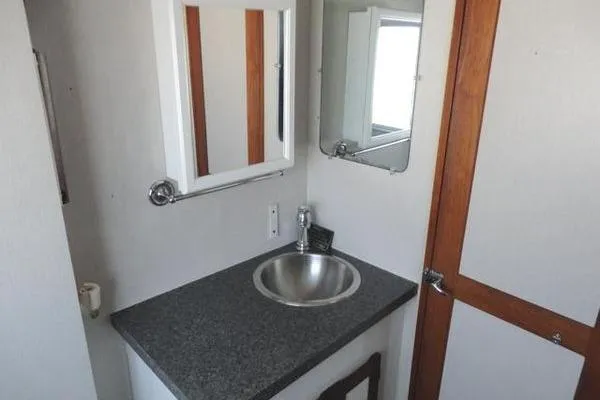 Slide: The Image of 1985 Pearson 43 Trawler bathroom with sink, mirror, and wooden accents. - 16