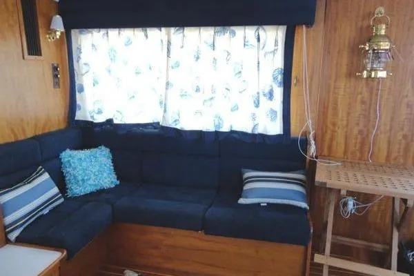 Slide: The Image of 1985 Pearson 43 Trawler interior with cozy seating, nautical decor, and wooden accents. - 18