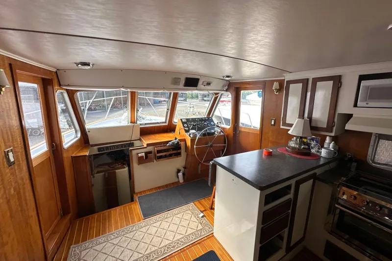 Slide: The Image of Interior of 1985 Pearson 43 Trawler with helm, kitchen, and wooden finishes. - 22