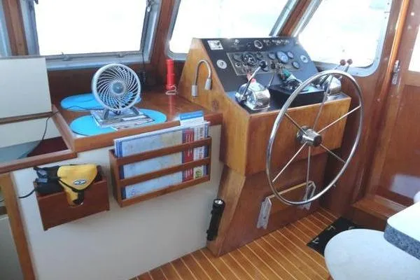 Slide: The Image of 1985 Pearson 43 Trawler helm with wooden dashboard, steering wheel, and navigation instruments. - 23