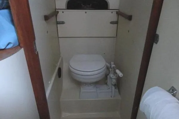 Slide: The Image of 1985 Pearson 43 Trawler bathroom with compact marine toilet and storage. - 32