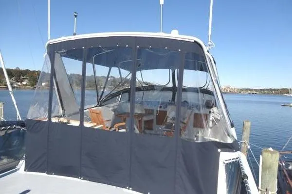 Slide: The Image of 1985 Pearson 43 Trawler with enclosed cockpit, docked by a serene waterfront. - 39