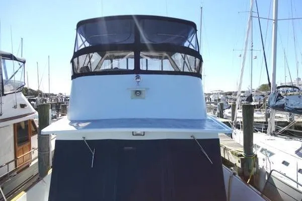Slide: The Image of 1985 Pearson 43 Trawler docked at marina, front view with blue canopy. - 49