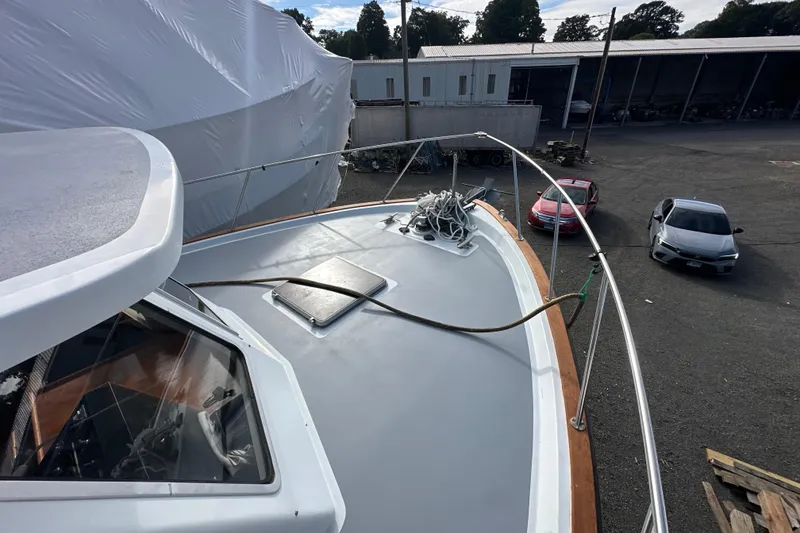 Slide: The Image of 1985 Pearson 43 Trawler on land, showing deck and surrounding vehicles. - 51