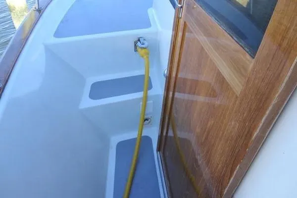 Slide: The Image of 1985 Pearson 43 Trawler deck with yellow hose and wooden door. - 54