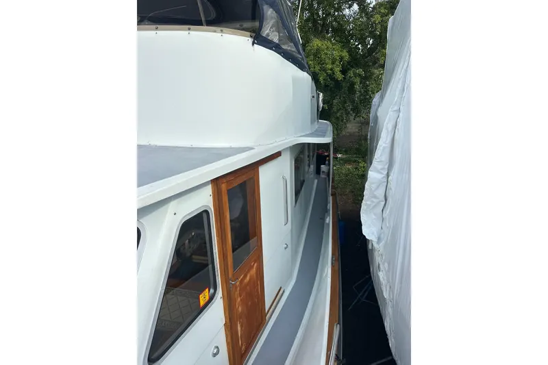 Slide: The Image of 1985 Pearson 43 Trawler side view, showcasing wooden door and sleek design. - 55