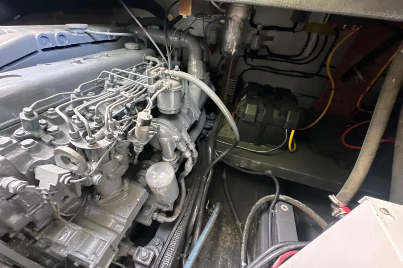 Slide: The Image of Engine compartment of a 1985 Pearson 43 Trawler, showcasing mechanical components and wiring. - 60