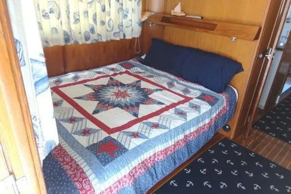 Slide: The Image of Cozy cabin bedroom in 1985 Pearson 43 Trawler with nautical-themed quilt and decor. - 7