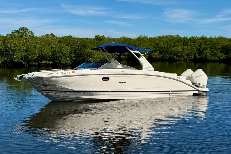 Slide: The Image of 2019 Sea Ray SDX 290 Outboard boat on calm water with lush greenery background. - 1