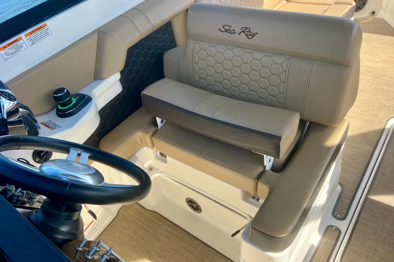Slide: The Image of 2019 Sea Ray SDX 290 Outboard helm with tan seating and steering wheel. - 12