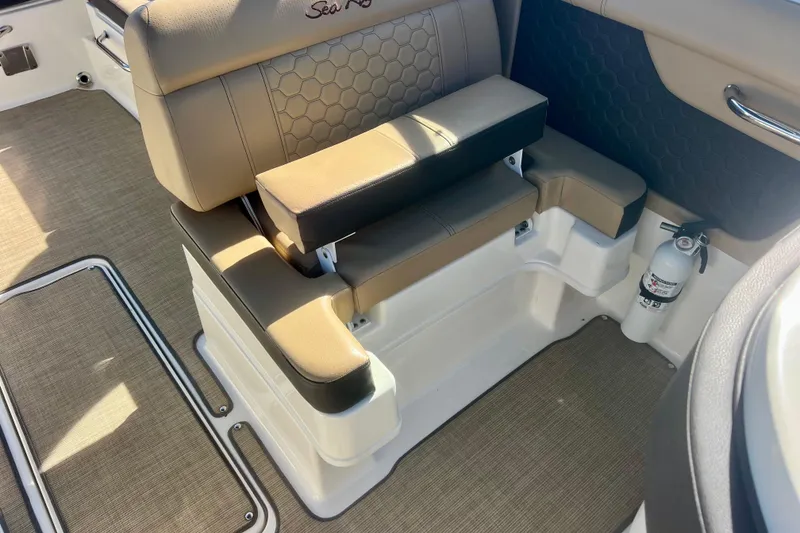 Slide: The Image of 2019 Sea Ray SDX 290 Outboard interior seating with beige upholstery and fire extinguisher. - 13