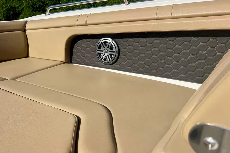 Slide: The Image of 2019 Sea Ray SDX 290 Outboard boat interior with beige seating and speaker detail. - 19