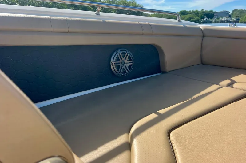 Slide: The Image of 2019 Sea Ray SDX 290 Outboard interior with beige seating and speaker detail. - 20