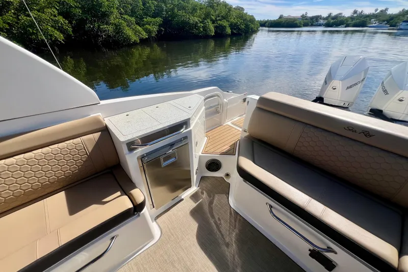 Slide: The Image of 2019 Sea Ray SDX 290 Outboard interior with seating, storage, and scenic water view. - 22