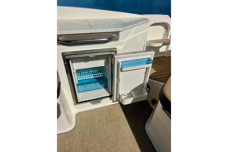 Slide: The Image of 2019 Sea Ray SDX 290 Outboard boat with open mini fridge, docked by water. - 23