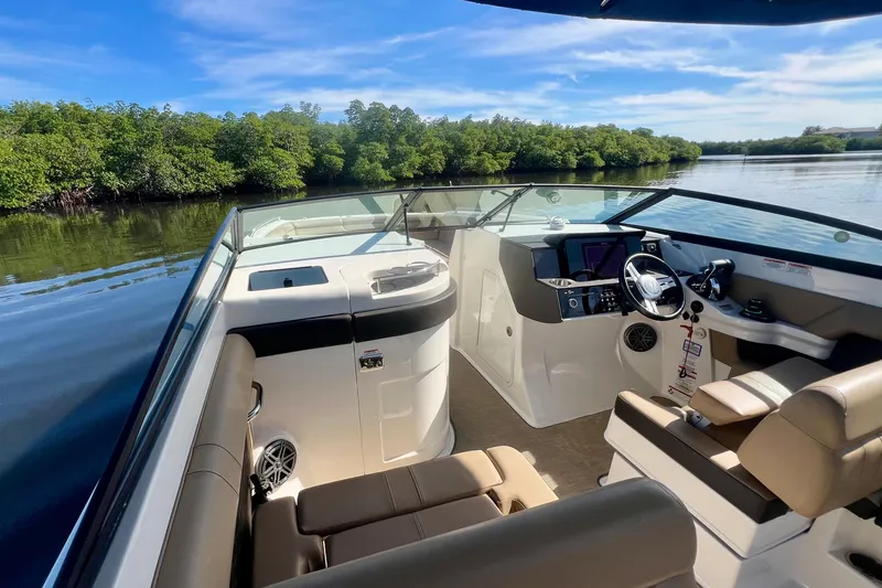 Slide: The Image of 2019 Sea Ray SDX 290 Outboard boat interior with sleek design and lush greenery backdrop. - 9