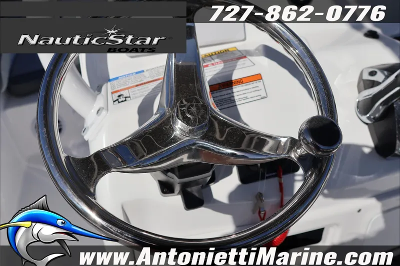 Slide: The Image of Steering wheel of 2026 NauticStar 231 Hybrid boat, featuring chrome finish and branding. - 42