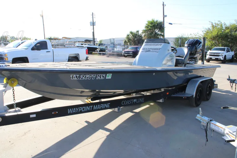 Slide: The Image of 2025 Mamba 227VX boat on trailer, parked in a marina lot. - 16