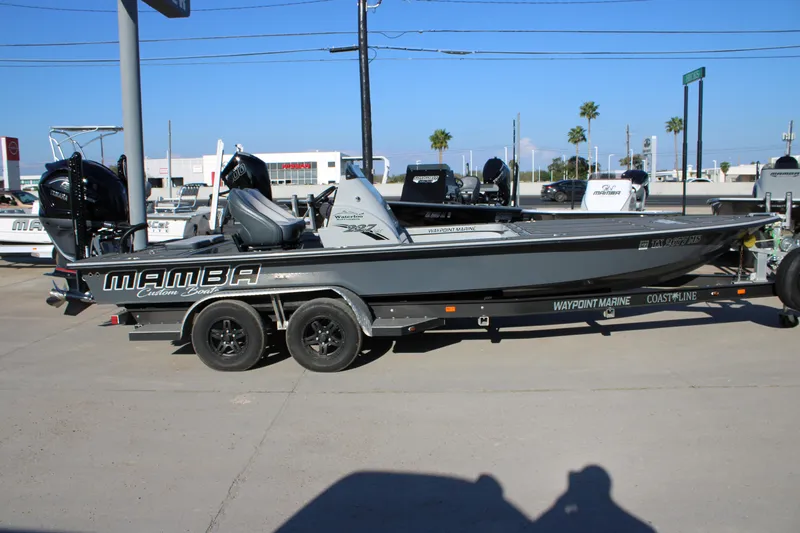 Slide: The Image of 2025 Mamba 227VX boat on trailer at dealership, showcasing sleek design and branding. - 17