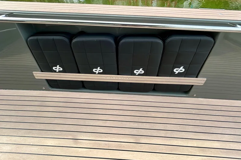 Slide: The Image of 2023 Pardo Yachts 43, sleek black seating with logo, on wooden deck. - 19
