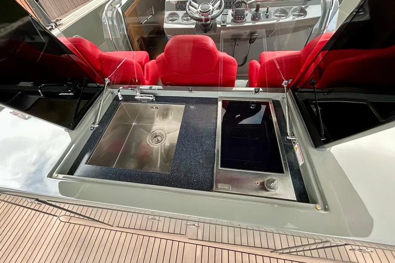 Slide: The Image of Luxury Pardo Yachts 43 interior with sleek kitchen sink and red seating, 2023 model. - 22