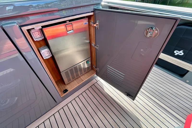 Slide: The Image of Open storage compartment on 2023 Pardo Yachts 43, featuring a built-in refrigerator. - 23