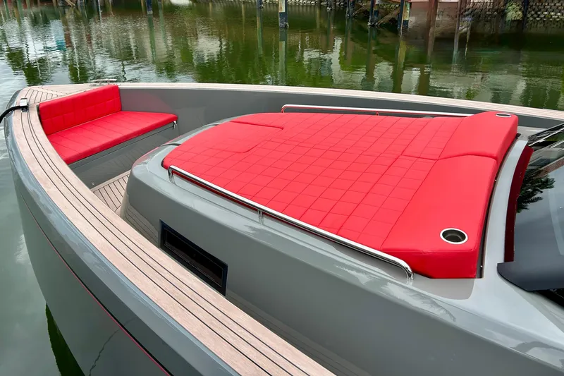 Slide: The Image of 2023 Pardo Yachts 43 with red cushioned seating and sleek design on calm water. - 25