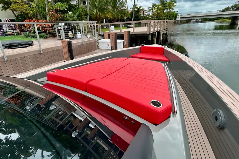 Slide: The Image of 2023 Pardo Yachts 43 with vibrant red seating, docked by a scenic waterfront. - 28
