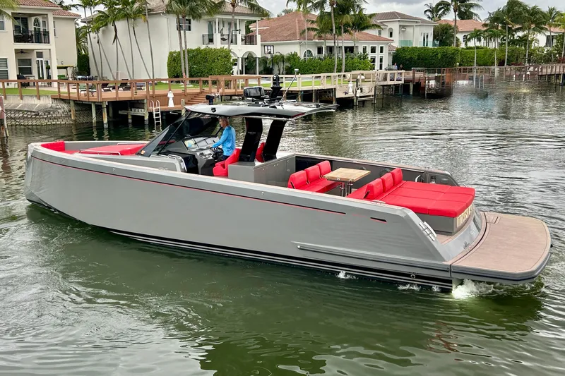 Slide: The Image of 2023 Pardo Yachts 43 with red seating, cruising near waterfront homes. - 3