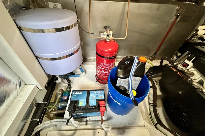 Slide: The Image of Engine room of 2023 Pardo Yachts 43 with fire extinguisher, battery, and maintenance supplies. - 55
