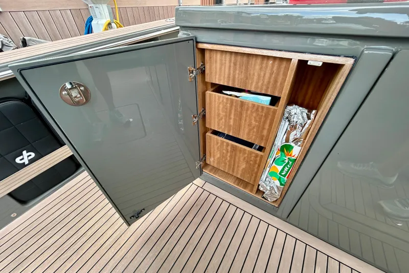 Slide: The Image of Open storage cabinet on 2023 Pardo Yachts 43, featuring wooden shelves and various items. - 24