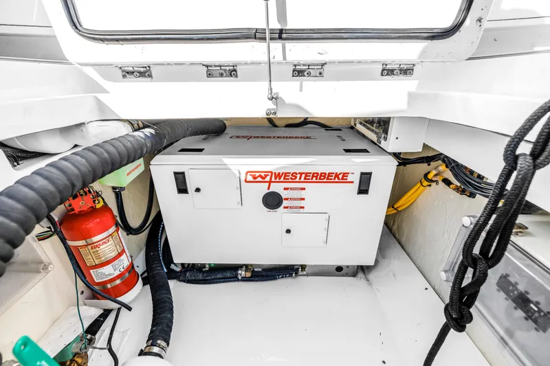 Slide: The Image of Engine room of 2023 HCB 53 Suenos RXV with Westerbeke generator and fire extinguisher. - 103
