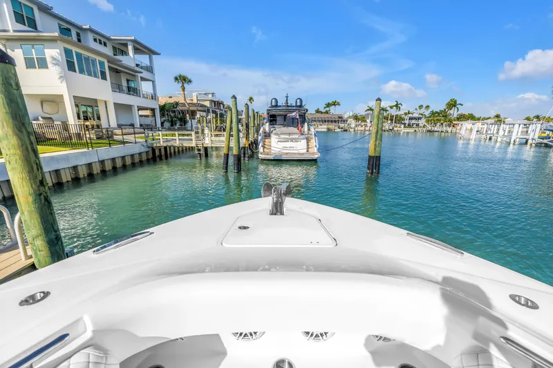 Slide: The Image of 2023 HCB 53 Suenos RXV yacht docked in a scenic marina with waterfront homes. - 12