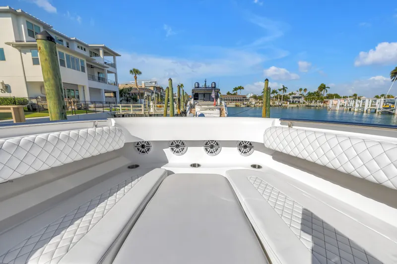 Slide: The Image of 2023 HCB 53 Suenos RXV luxury boat interior with quilted seating, docked in a sunny marina. - 13