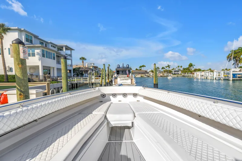 Slide: The Image of 2023 HCB 53 Suenos RXV boat docked in a sunny marina with waterfront homes. - 14