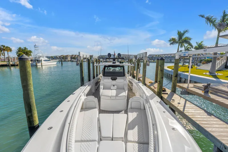 Slide: The Image of 2023 HCB 53 Suenos RXV luxury boat docked in a sunny marina setting. - 25