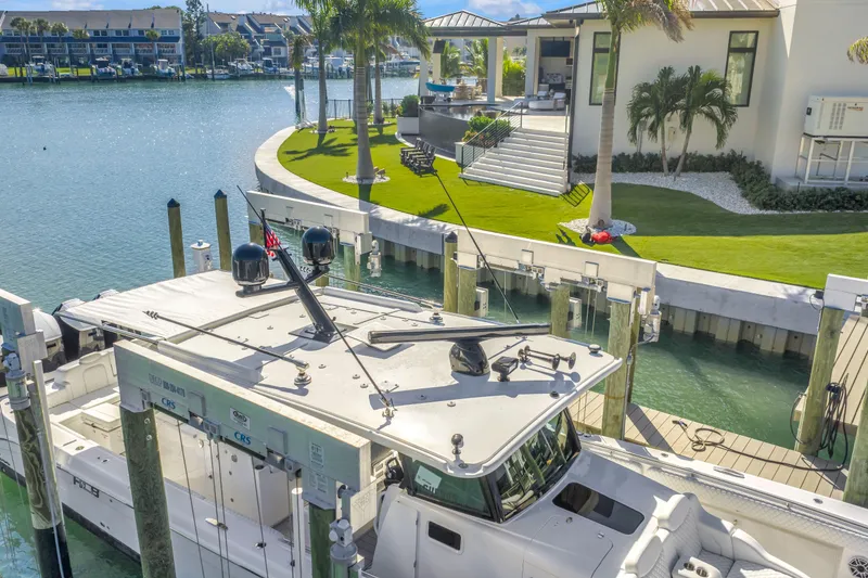 Slide: The Image of 2023 HCB 53 Suenos RXV docked by a waterfront home with lush landscaping. - 33