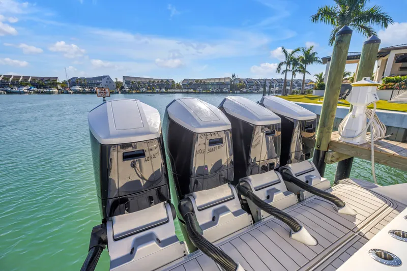 Slide: The Image of 2023 HCB 53 Suenos RXV boat with four powerful outboard engines docked by the water. - 70