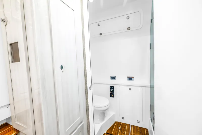 Slide: The Image of 2023 HCB 53 Suenos RXV boat bathroom with sleek white interior and wooden flooring. - 78