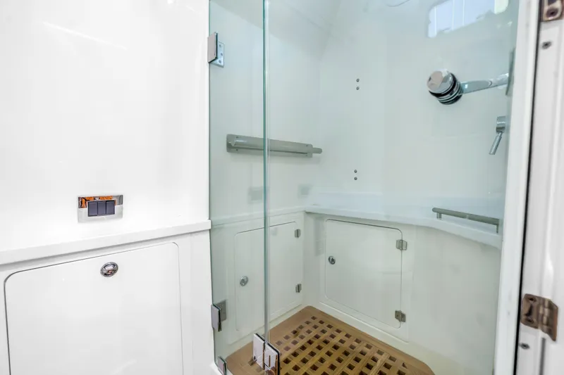 Slide: The Image of Luxurious shower area in 2023 HCB 53 Suenos RXV boat with glass door and wooden floor. - 84