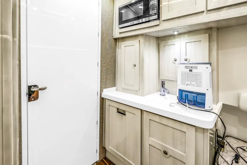 Slide: The Image of 2023 HCB 53 Suenos RXV interior with kitchenette, microwave, and water purifier. - 88