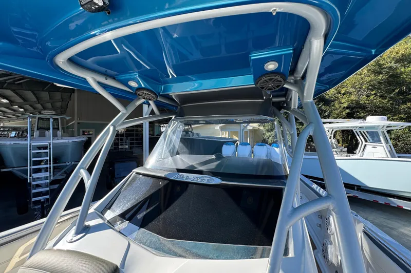 Slide: The Image of 2016 Nor-Tech 390 Sport Center Console boat with blue canopy and sleek design. - 25
