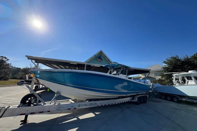 Slide: The Image of 2016 Nor-Tech 390 Sport Center Console boat on trailer under clear blue sky. - 4