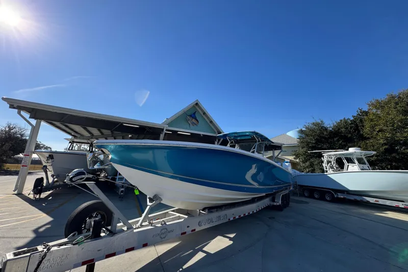 Slide: The Image of 2016 Nor-Tech 390 Sport Center Console boat on trailer under clear blue sky. - 5
