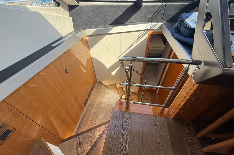 Slide: The Image of Interior staircase of 2017 Sunseeker Manhattan 65 yacht, featuring wooden finish and modern design. - 15